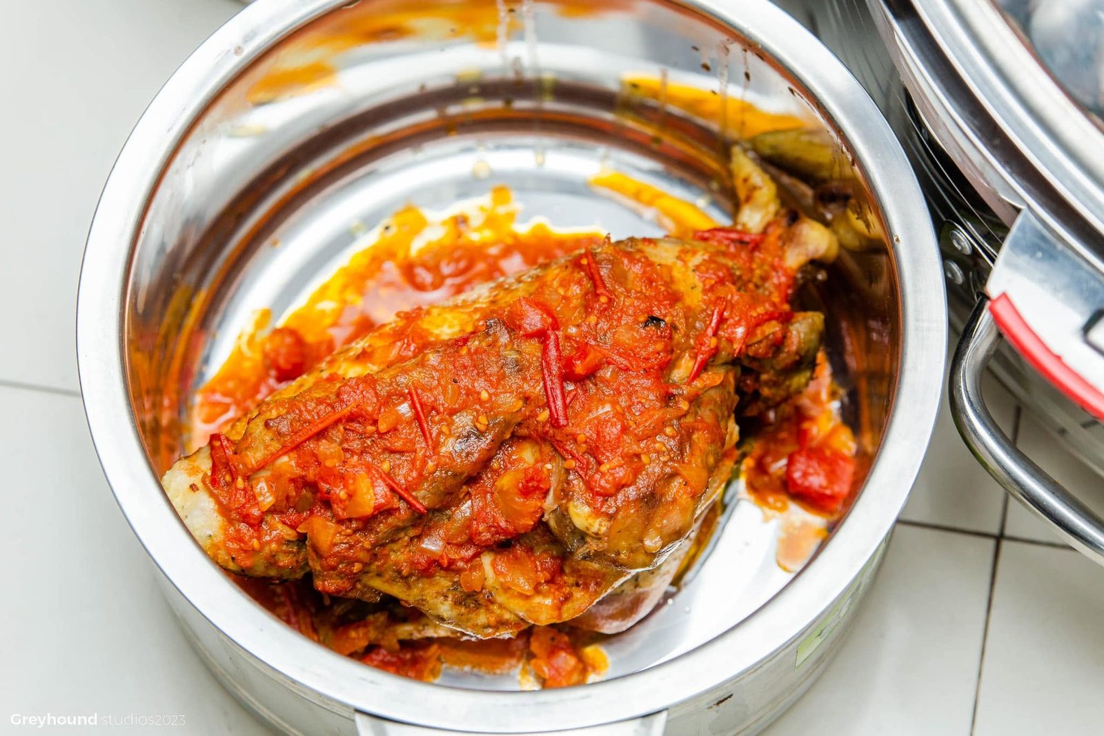 Fish in tomato sauce in a steel pot